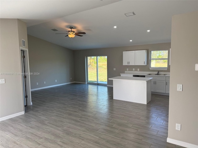 kitchen featuring a center island, sink, ceiling fan, light wood-type flooring, and white cabinetry