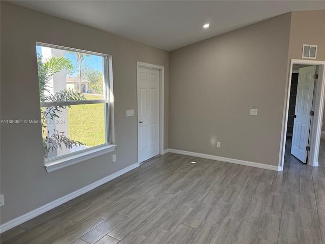 unfurnished room with light wood-type flooring and a healthy amount of sunlight