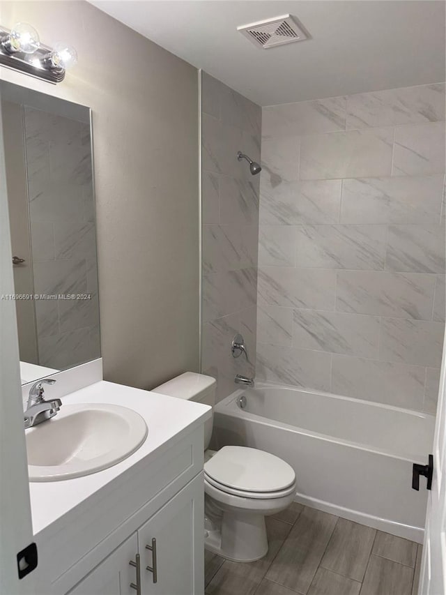 full bathroom featuring vanity, toilet, and tiled shower / bath