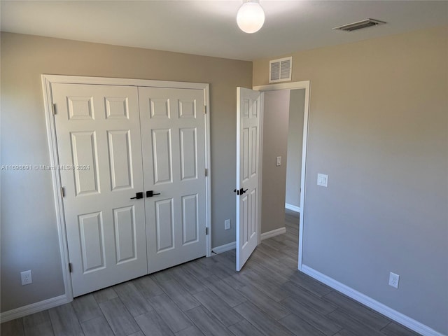 unfurnished bedroom featuring hardwood / wood-style floors and a closet