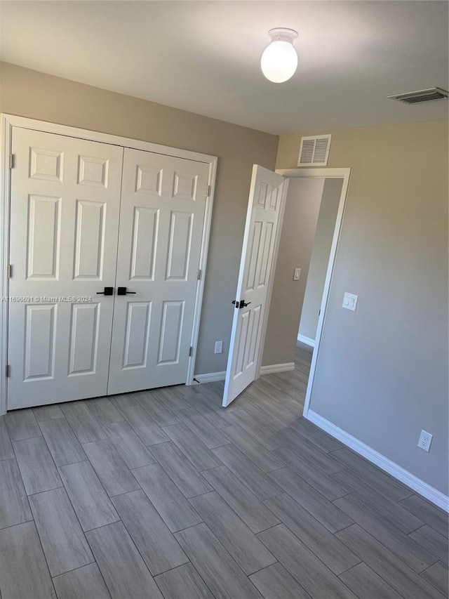 unfurnished bedroom featuring light hardwood / wood-style floors and a closet