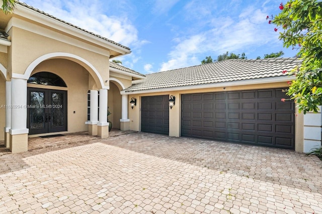 view of front facade with a garage and french doors