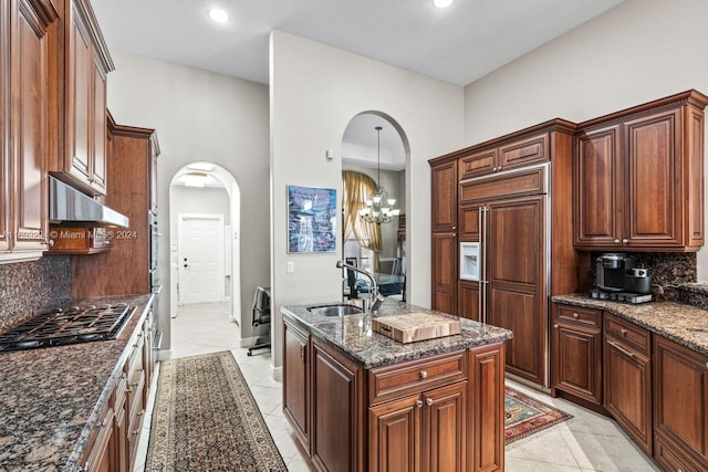 kitchen with backsplash, a chandelier, sink, and stainless steel appliances