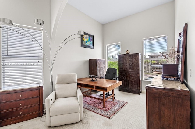 office area with light carpet and a high ceiling