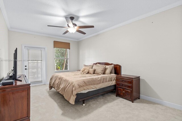 carpeted bedroom featuring ceiling fan, crown molding, and a textured ceiling