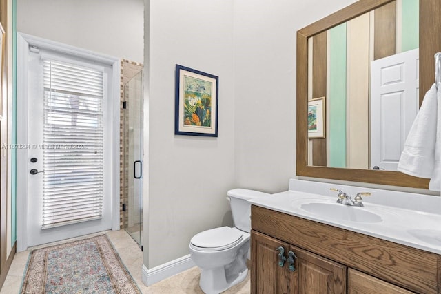 bathroom with tile patterned flooring, vanity, toilet, and a shower with shower door