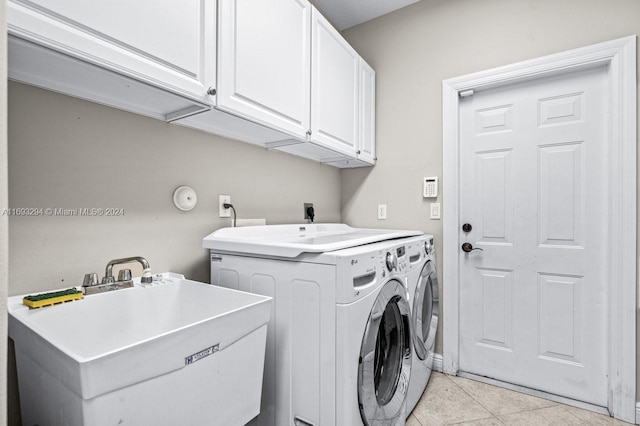 washroom with cabinets, light tile patterned floors, independent washer and dryer, and sink