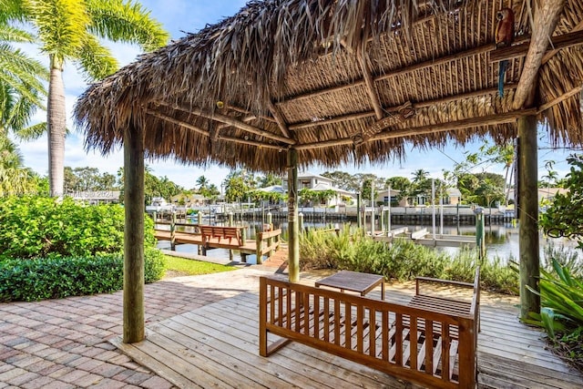 deck with a gazebo, a boat dock, and a water view