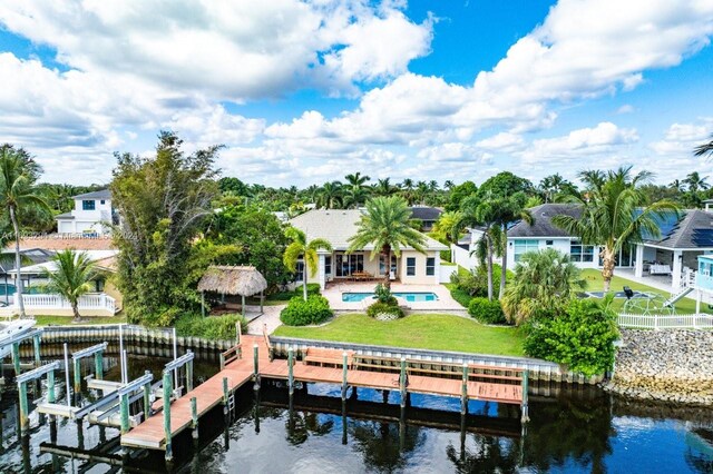 view of dock featuring a patio area, a water view, and a yard