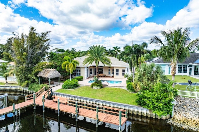 rear view of house featuring a lawn, a patio area, and a water view