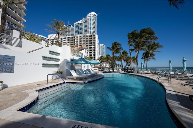 view of pool with a patio and a water view