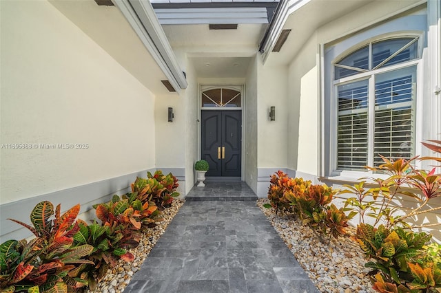 doorway to property featuring stucco siding