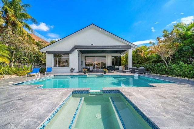 view of swimming pool with a patio area, a pool with connected hot tub, and fence