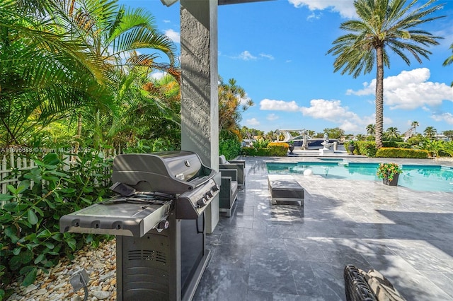 outdoor pool featuring a patio, exterior kitchen, and area for grilling