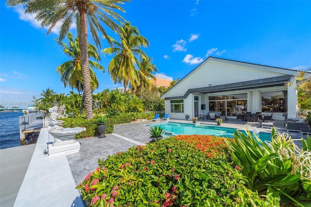 view of pool featuring a patio area and a water view