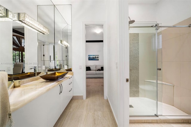 bathroom with tile patterned flooring, vanity, and a shower with door