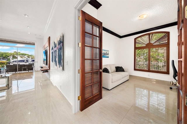 hallway featuring light tile patterned floors, a textured ceiling, and crown molding