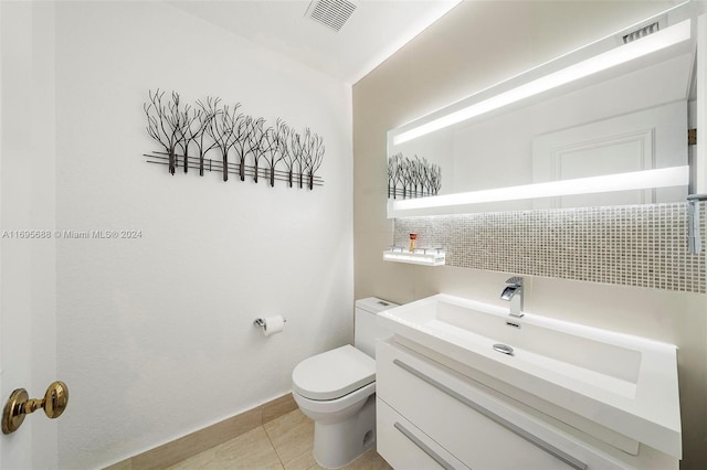 bathroom featuring decorative backsplash, tile patterned floors, vanity, and toilet