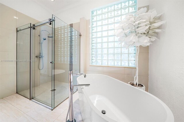 bathroom featuring plus walk in shower, tile patterned flooring, and crown molding