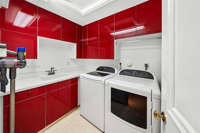 laundry area featuring cabinets, a textured ceiling, sink, light tile patterned floors, and washing machine and dryer