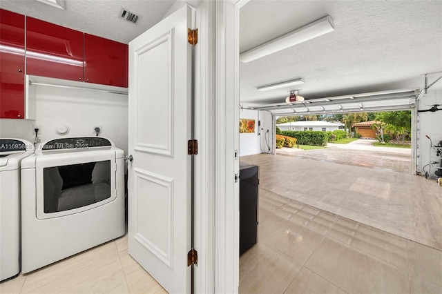 laundry room featuring a garage, laundry area, visible vents, a textured ceiling, and hookup for an electric dryer