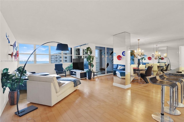 living room with light hardwood / wood-style flooring and a notable chandelier