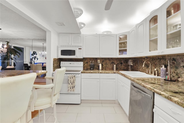 kitchen with white cabinetry, white appliances, light stone countertops, and sink