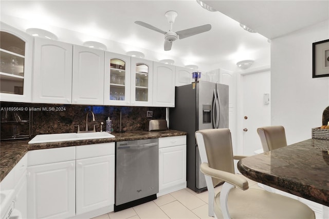 kitchen featuring appliances with stainless steel finishes, sink, white cabinets, decorative backsplash, and ceiling fan