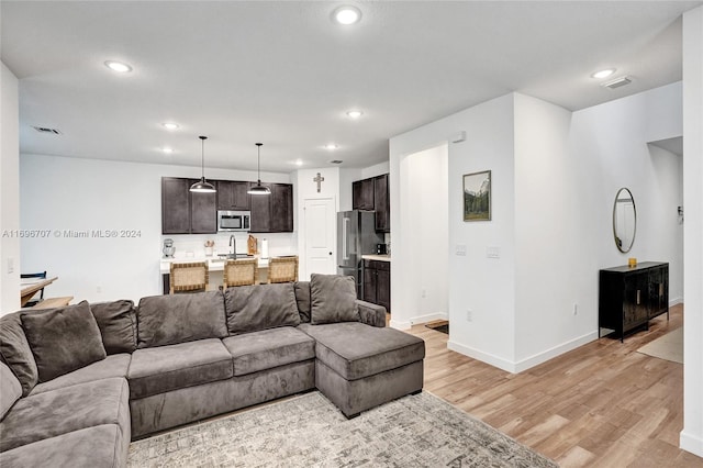 living room with light hardwood / wood-style floors and sink