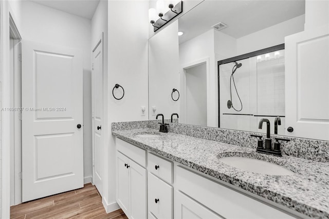 bathroom featuring vanity, wood-type flooring, and walk in shower