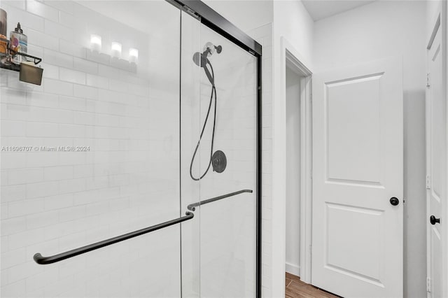 bathroom featuring wood-type flooring and walk in shower