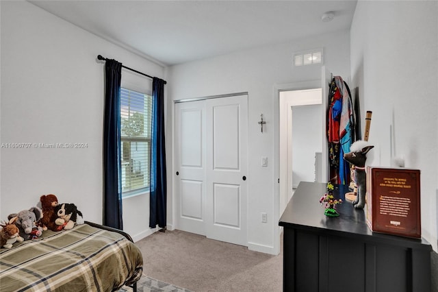 bedroom with light colored carpet and a closet