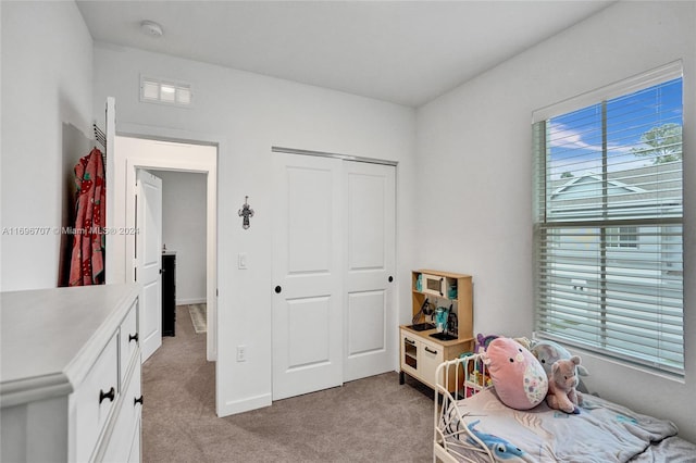 bedroom featuring light carpet and a closet