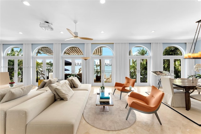 living room featuring ceiling fan, a wealth of natural light, and french doors