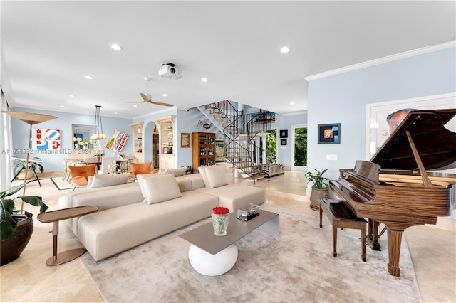 living room featuring ceiling fan with notable chandelier and crown molding