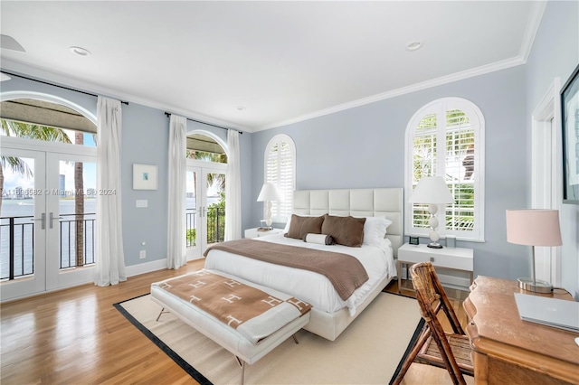 bedroom featuring access to exterior, french doors, light hardwood / wood-style flooring, and crown molding