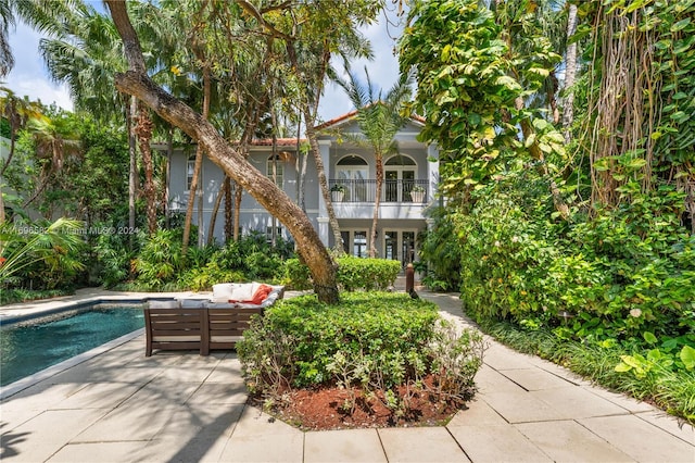 exterior space with an outdoor living space, a patio area, and a swimming pool