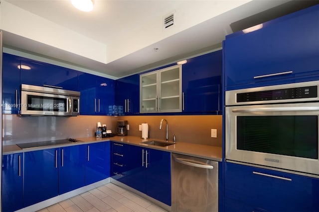 kitchen with sink, blue cabinets, and appliances with stainless steel finishes