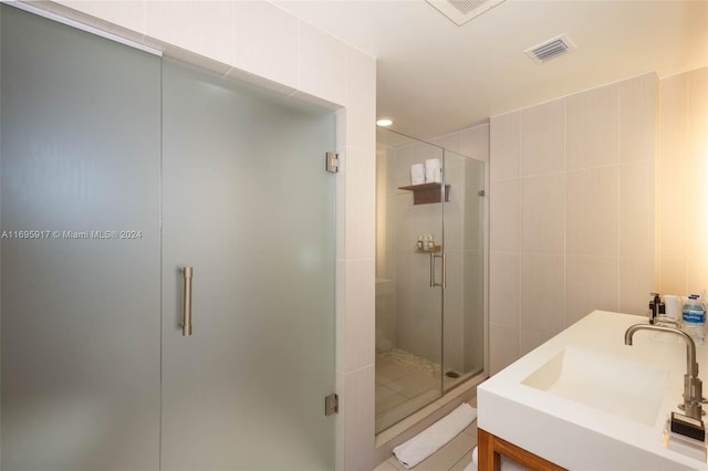 bathroom with vanity, tile walls, and walk in shower