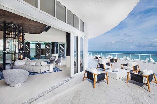 balcony featuring an outdoor living space and a water view