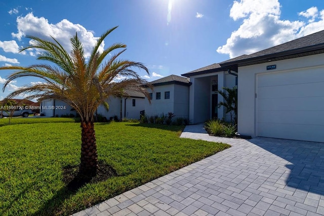 single story home with a garage and a front lawn