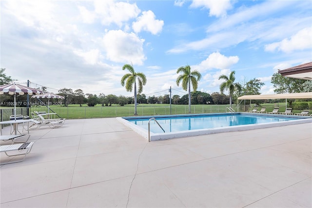 view of pool with a patio area and a lawn