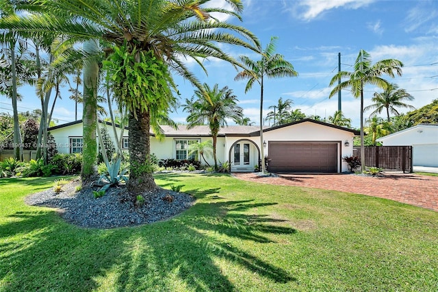 ranch-style home with a garage, a front yard, and french doors