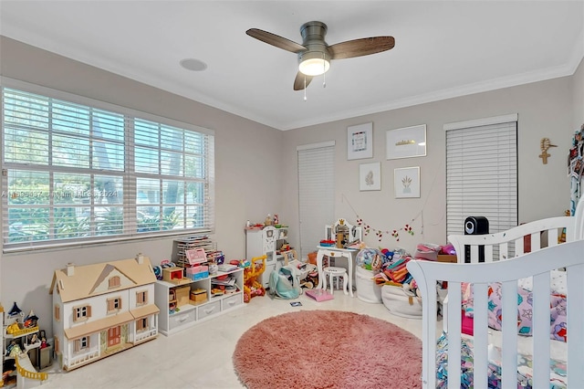 bedroom with ceiling fan, a crib, crown molding, and carpet floors