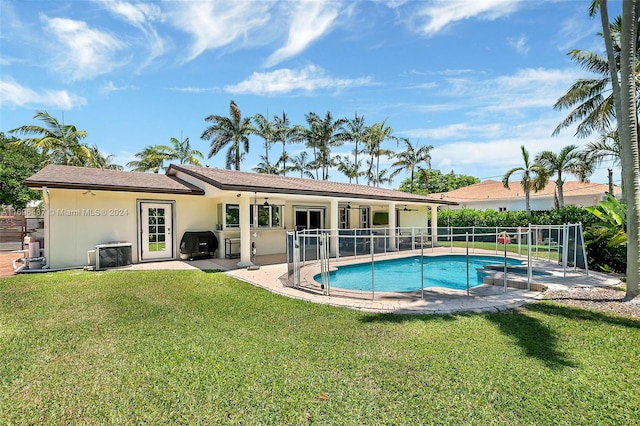 view of pool featuring a lawn, ceiling fan, central AC, a grill, and a patio area