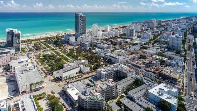 birds eye view of property featuring a beach view and a water view