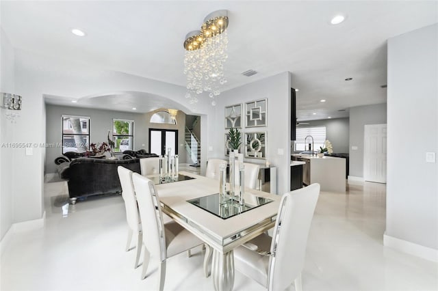 dining area featuring a chandelier and sink