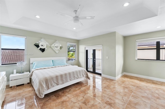 bedroom featuring french doors, a raised ceiling, and ceiling fan