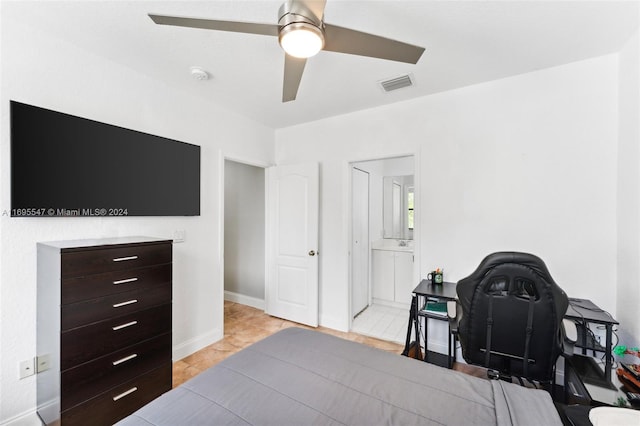 tiled bedroom featuring connected bathroom and ceiling fan