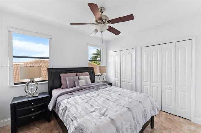 bedroom featuring ceiling fan and two closets